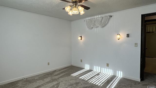 empty room with carpet flooring, ceiling fan, and a textured ceiling