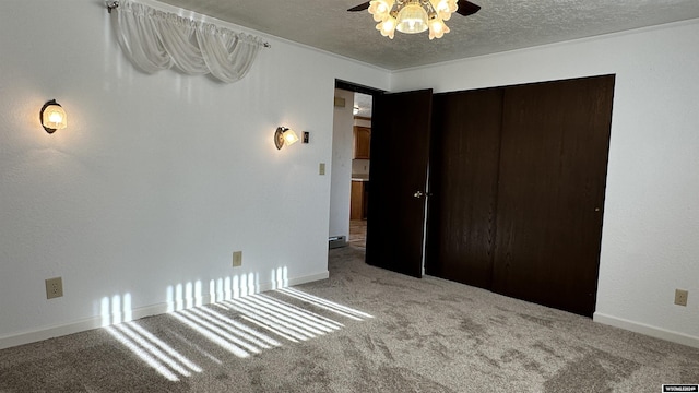 unfurnished bedroom featuring ceiling fan, a closet, carpet floors, and a textured ceiling