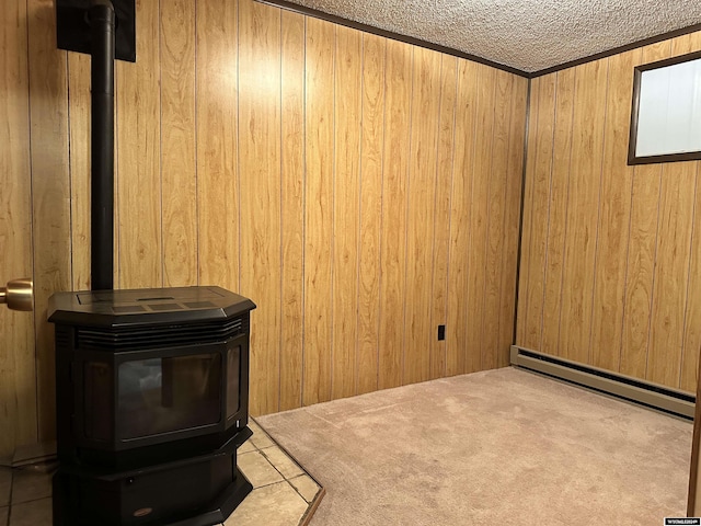 interior space with carpet flooring, a textured ceiling, wooden walls, and a baseboard heating unit