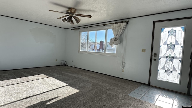 entryway with carpet, ceiling fan, a healthy amount of sunlight, and a textured ceiling