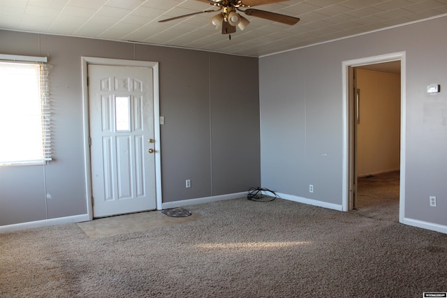 foyer featuring ceiling fan and carpet