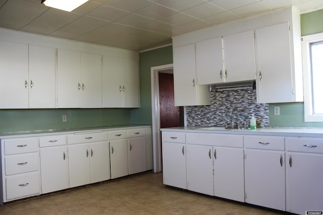 kitchen featuring backsplash, white cabinetry, and sink