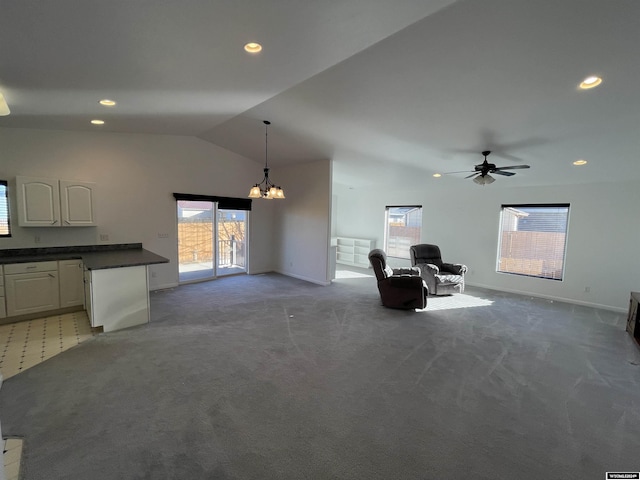 unfurnished living room with carpet, ceiling fan with notable chandelier, and lofted ceiling