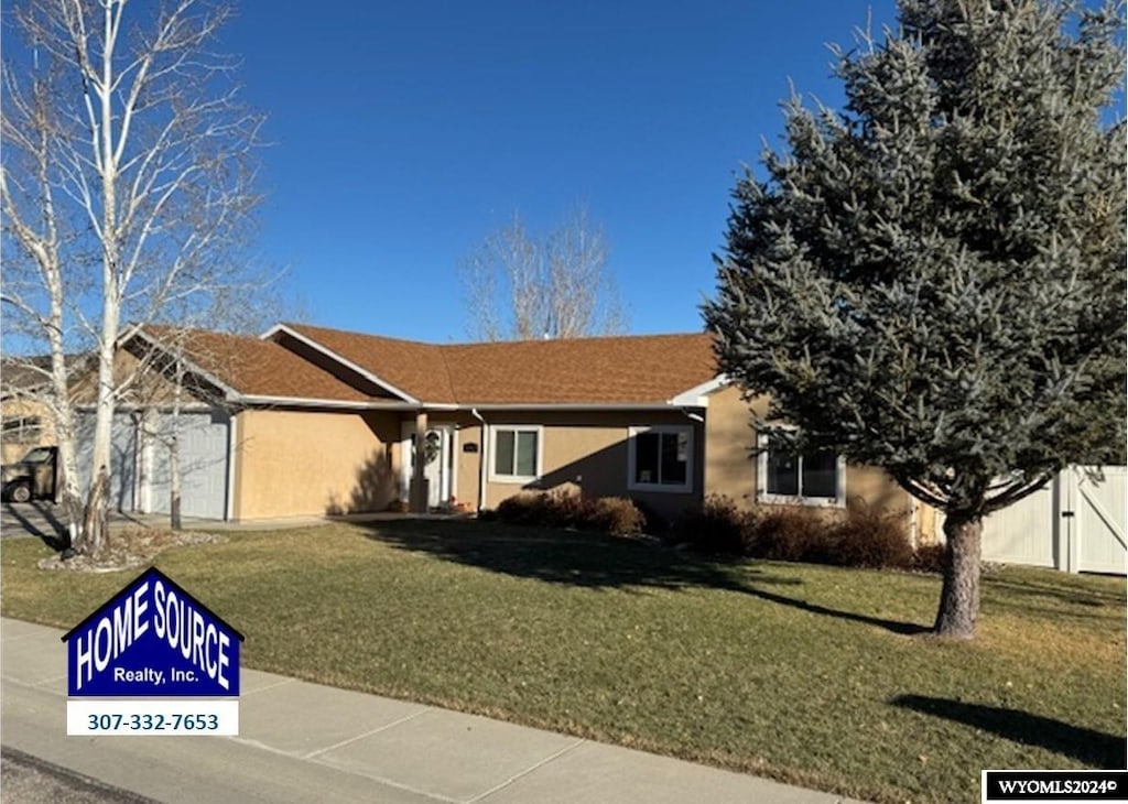 view of front of house with a front yard and a garage