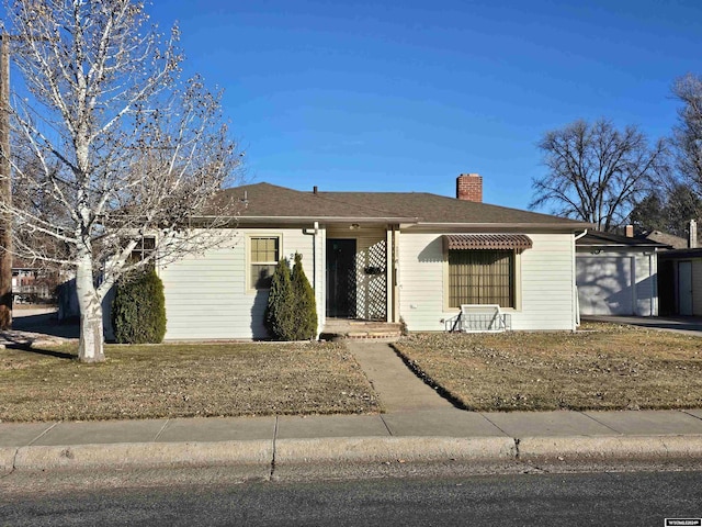 single story home with a front yard and a garage