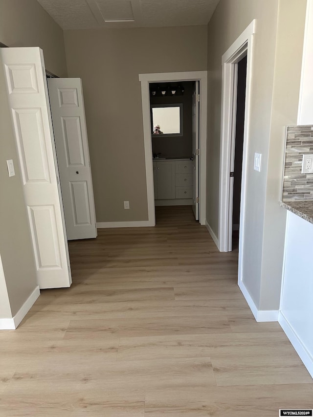 corridor with light hardwood / wood-style floors