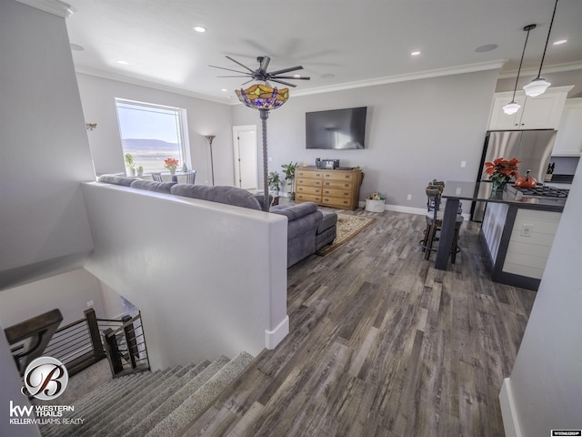 living room featuring crown molding, ceiling fan, and dark hardwood / wood-style floors