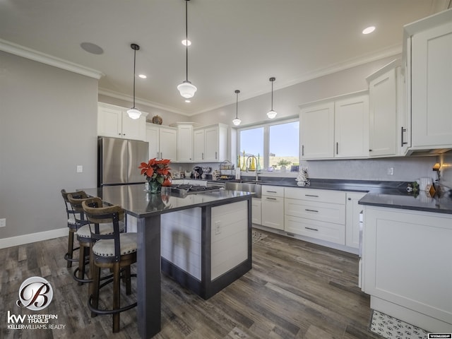 kitchen featuring stainless steel refrigerator, sink, hanging light fixtures, dark hardwood / wood-style floors, and white cabinets