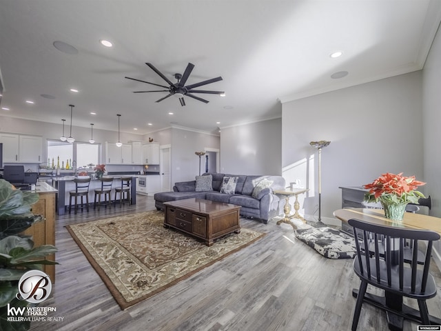 living room with ceiling fan, wood-type flooring, and ornamental molding