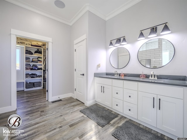 bathroom with wood-type flooring, vanity, and crown molding