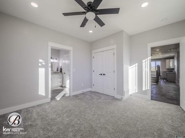 unfurnished bedroom featuring connected bathroom, ceiling fan, a closet, and carpet