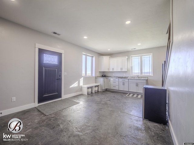 kitchen featuring a healthy amount of sunlight, white cabinetry, and sink