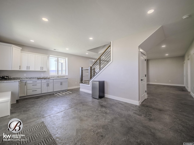 kitchen featuring light stone countertops and white cabinets