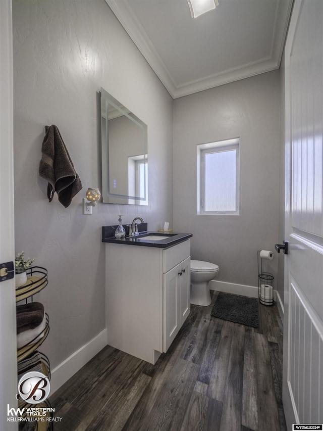 bathroom with hardwood / wood-style floors, vanity, toilet, and crown molding