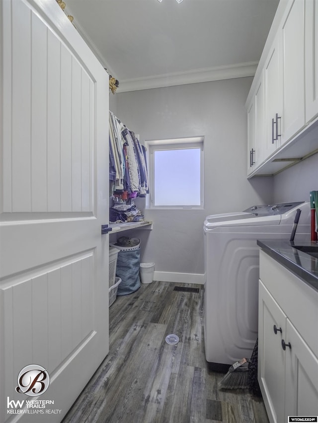 laundry area with crown molding, washer and clothes dryer, cabinets, and dark wood-type flooring