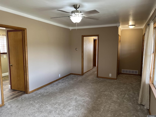 unfurnished bedroom featuring ceiling fan, dark carpet, and ornamental molding