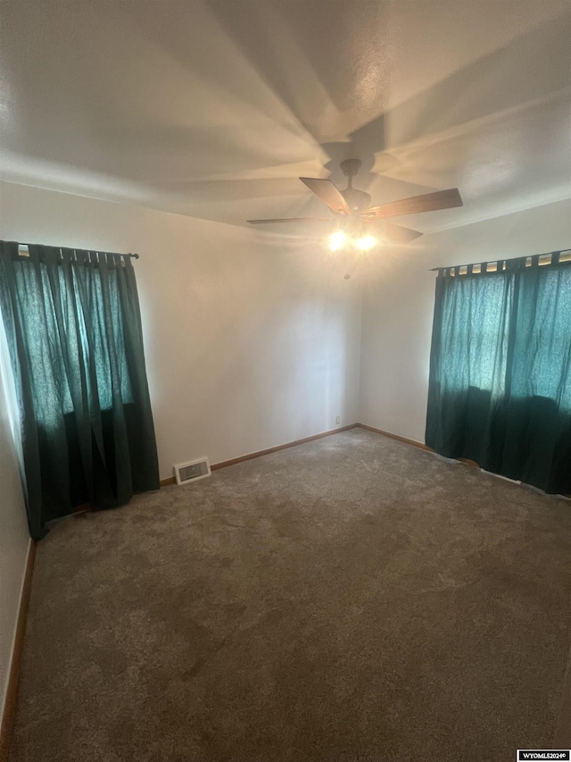 carpeted spare room featuring ceiling fan