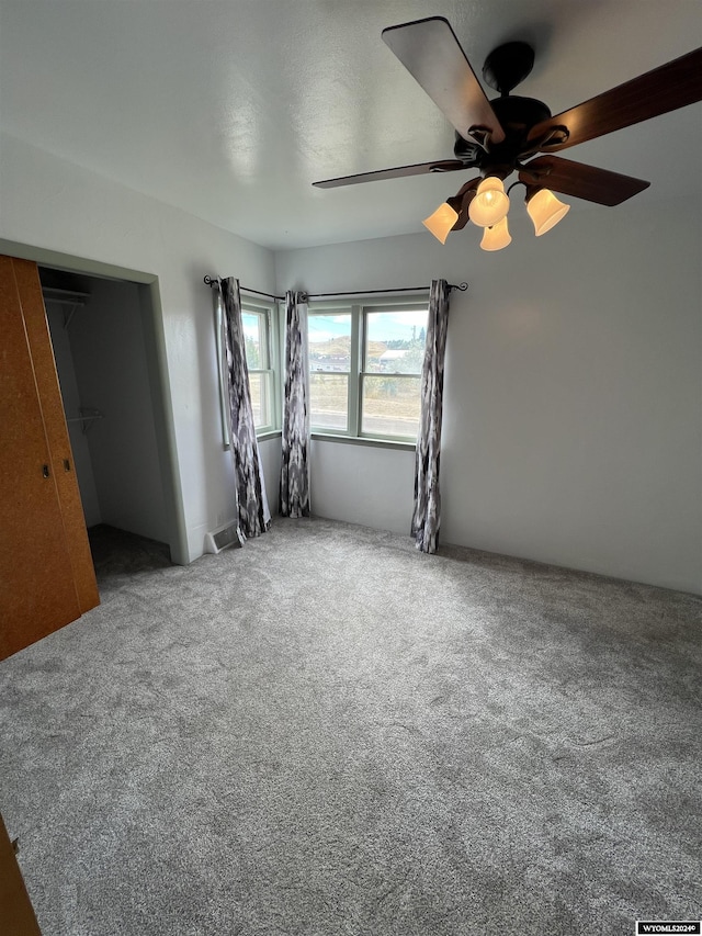 unfurnished bedroom featuring carpet floors, a closet, and ceiling fan