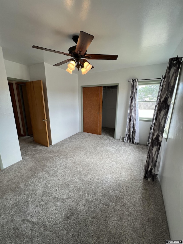 unfurnished bedroom featuring ceiling fan, a closet, and carpet floors