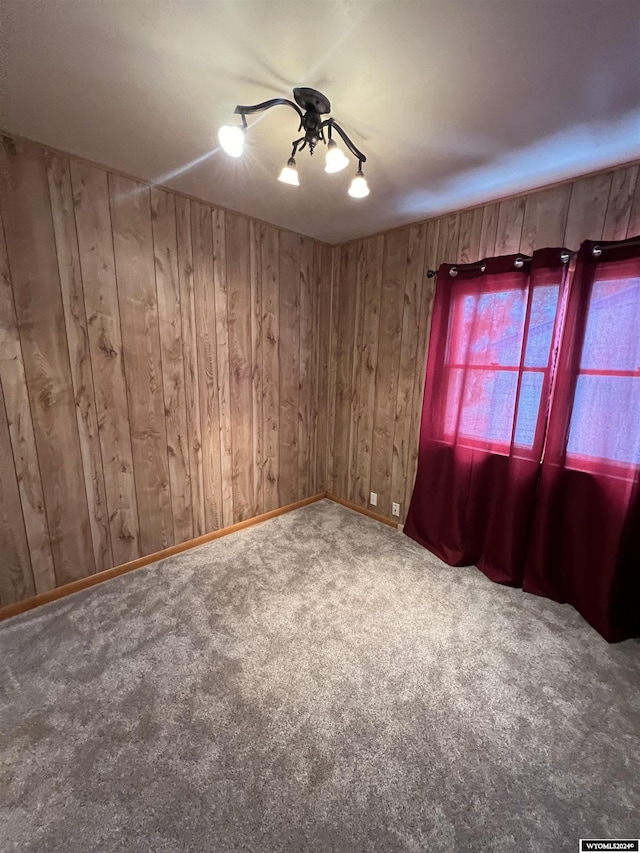 carpeted empty room with wooden walls