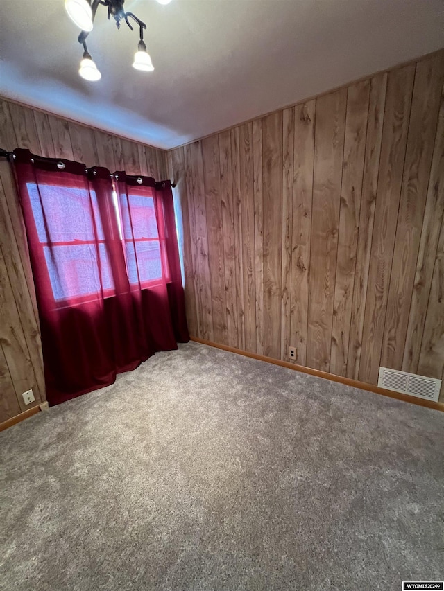 610 Charles St, Douglas, WY 82633 - empty room featuring carpet, wood walls, and baseboards