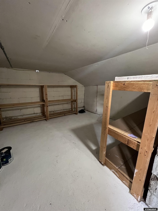 additional living space featuring lofted ceiling and concrete flooring