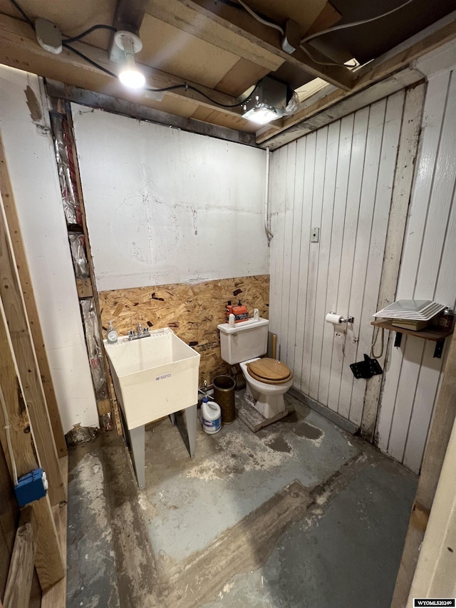 bathroom with concrete floors, toilet, and sink