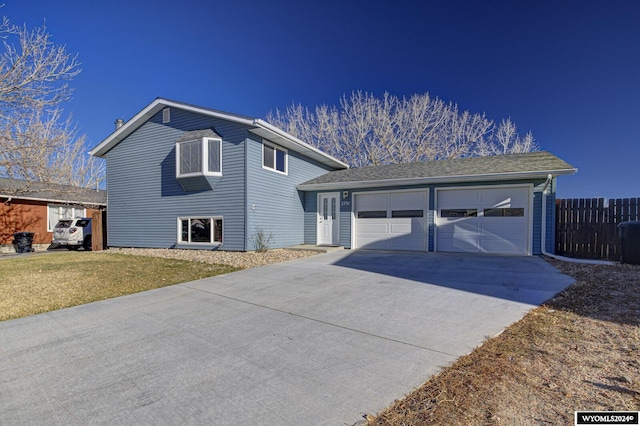 tri-level home with a garage and a front yard