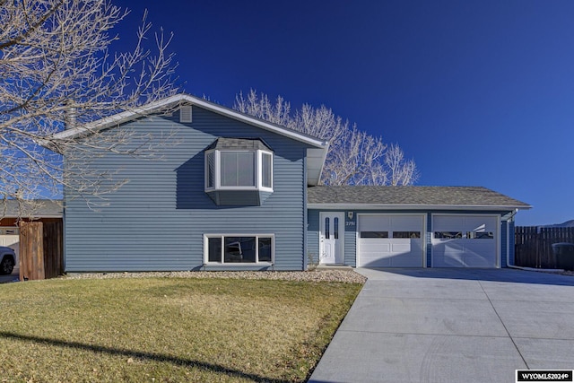 tri-level home featuring a front yard and a garage