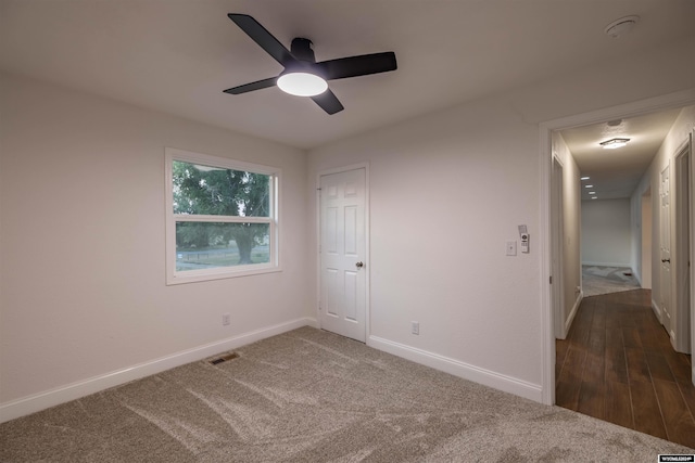 empty room with ceiling fan and dark hardwood / wood-style flooring