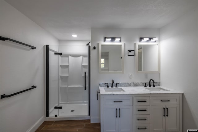 bathroom with hardwood / wood-style flooring, vanity, and a shower with shower door