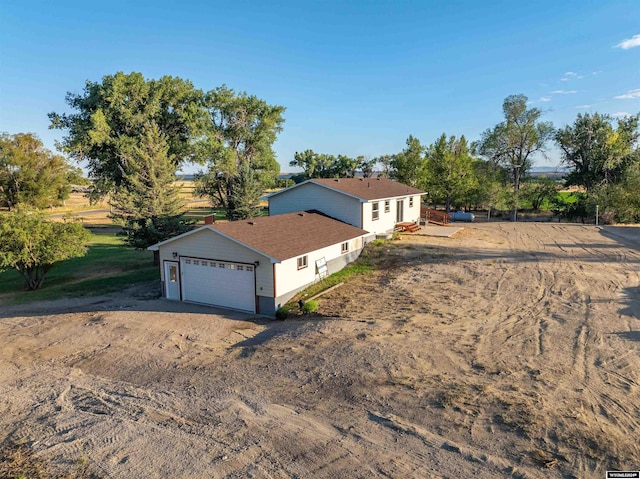 view of front of home with a rural view and a garage