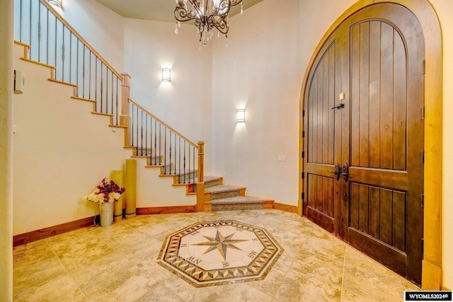 entryway featuring a towering ceiling and an inviting chandelier