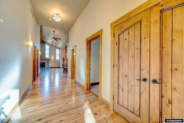 corridor featuring light hardwood / wood-style floors and vaulted ceiling