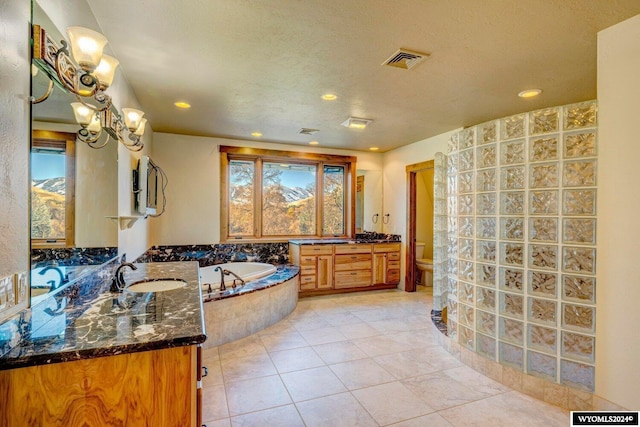 bathroom featuring an inviting chandelier, tile patterned floors, tiled bath, toilet, and vanity