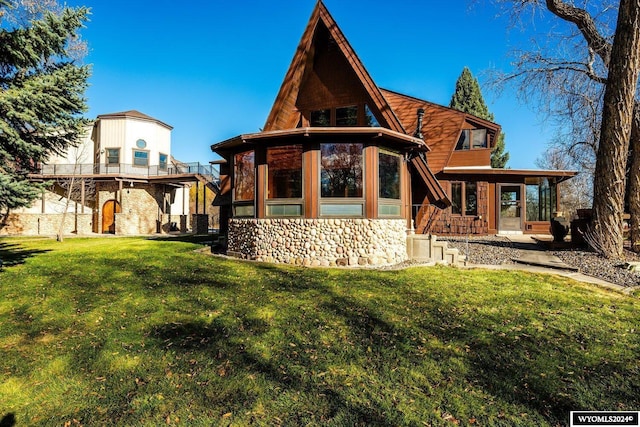 back of house featuring a lawn and a sunroom