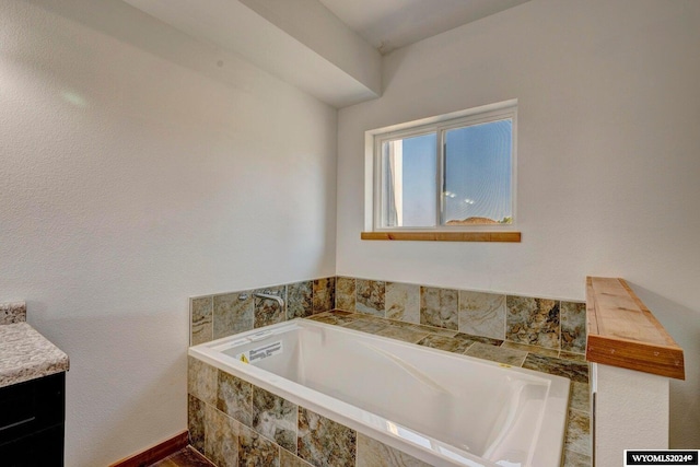 bathroom featuring vanity and tiled bath