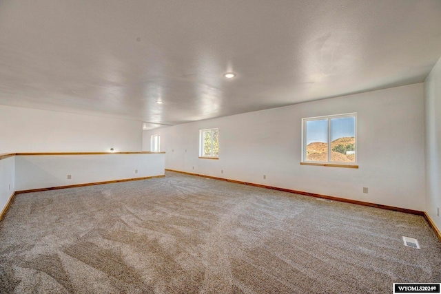 carpeted spare room featuring a wealth of natural light