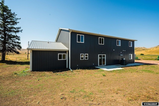 rear view of property with a lawn and a patio area