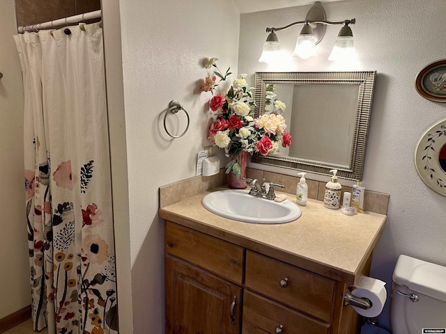 bathroom with a shower with shower curtain, vanity, and toilet