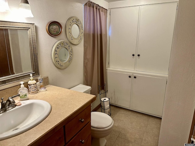 bathroom with tile patterned flooring, vanity, and toilet