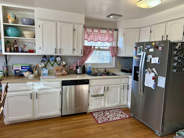 kitchen featuring white cabinets, appliances with stainless steel finishes, light hardwood / wood-style flooring, and sink