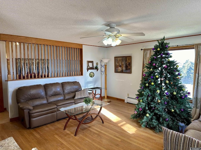 living room with a textured ceiling, light wood-type flooring, a baseboard radiator, and ceiling fan