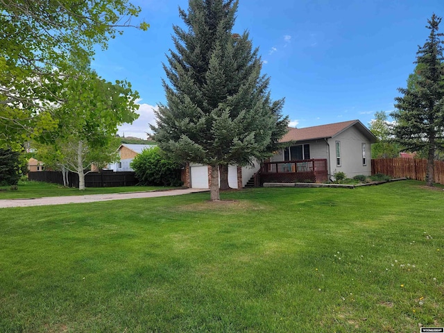 view of front of house featuring a wooden deck, a front yard, and a garage