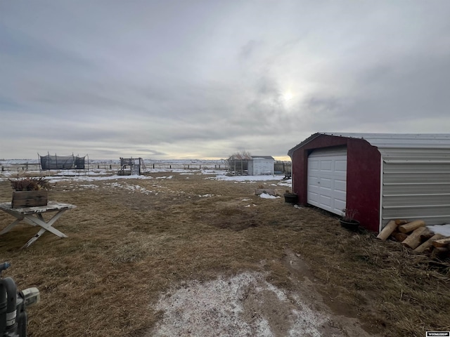 view of yard with a trampoline and an outbuilding