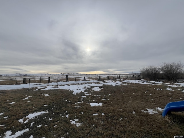 snowy yard featuring a rural view