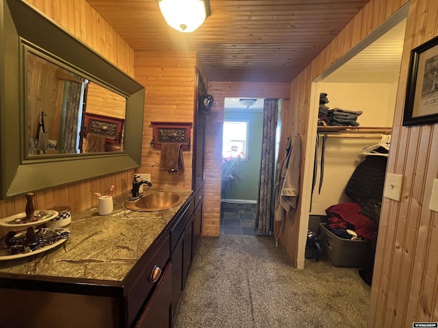 interior space with vanity, wood ceiling, and wooden walls