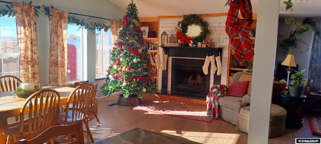 interior space with a fireplace, wood-type flooring, and lofted ceiling