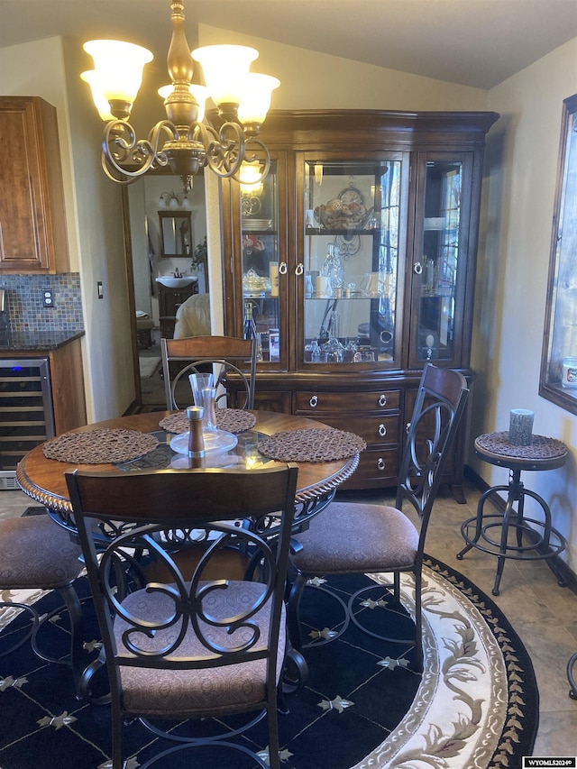 tiled dining space with vaulted ceiling, beverage cooler, and a notable chandelier