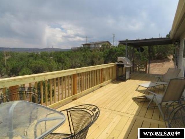 wooden deck featuring a grill